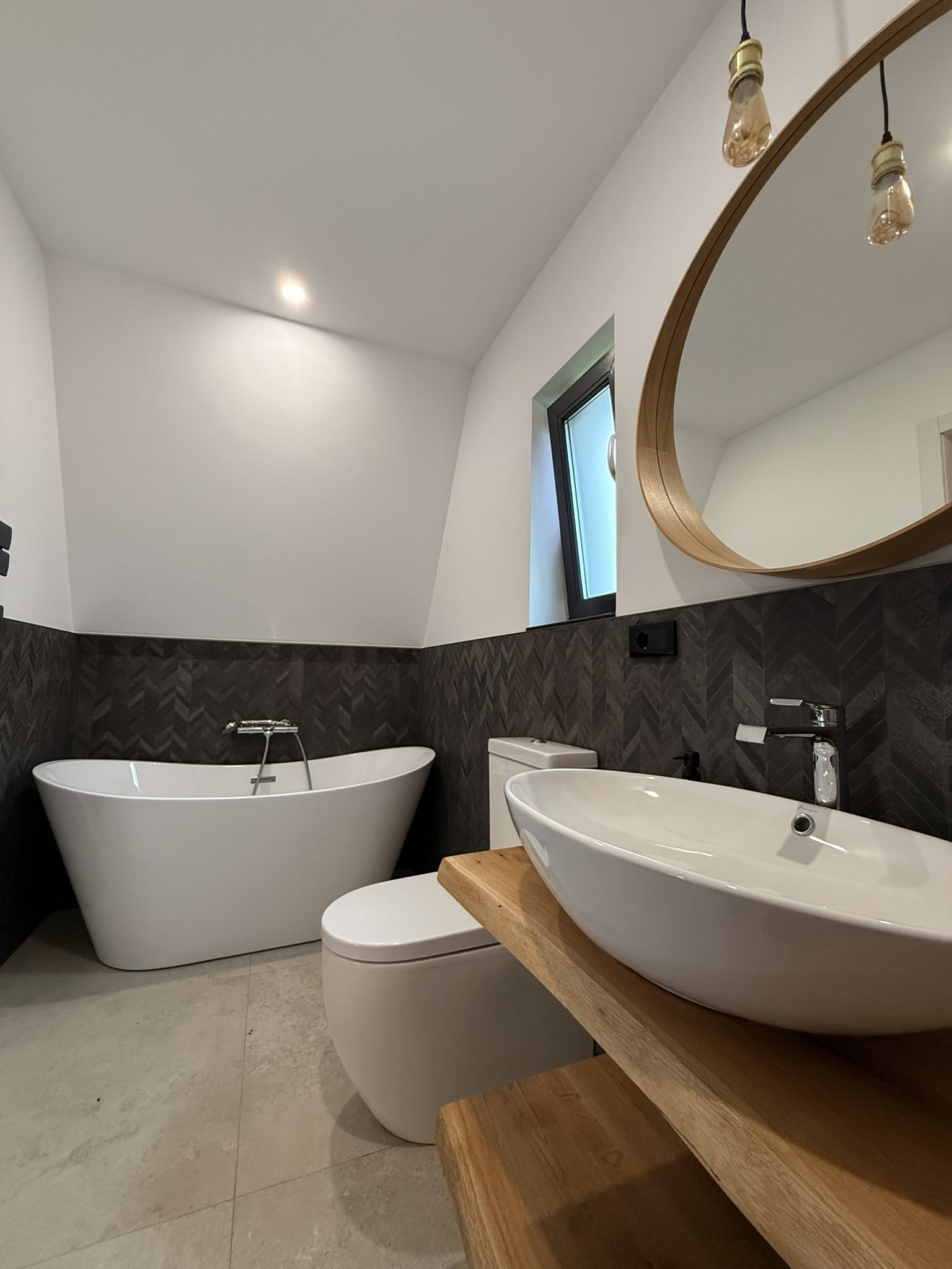 Baia cu faianță herringbone — cadă freestanding și oglindă rotundă